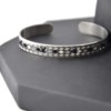 Bracelet-Jonc-Ouvert-Acier-Argente-avec-Motif-Fleches-Losanges-et-Fils-Noir
